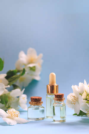 Tender jasmine flowers and oil. Small bottle with cosmetic (cleansing) aroma oil and white jasmine flowers. Natural skin care, homemade spa and beauty treatment recipe. Copy spaceの写真素材