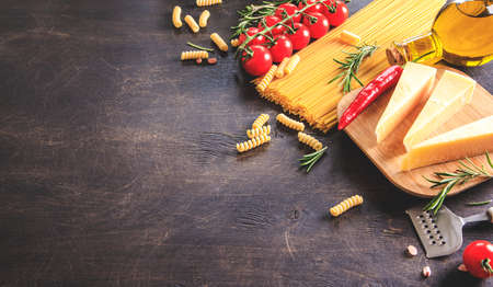 Uncooked pasta on wooden background. Top view. Raw pasta with ingredients for cooking. Food concept. Italian food.の写真素材