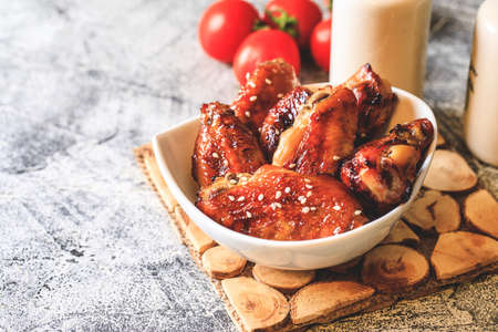 baked chicken wings with crispy crust on plate and gray backgroundの写真素材