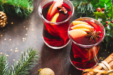 Christmas mulled wine with spices on a wooden rustic table. Christmas hot drink. Christmas decoration. Close up.の写真素材