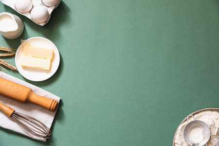 Frame of food ingredients for baking on a green pastel background. Cooking flat lay with copy space. top view. Baking concept. mockup.の写真素材
