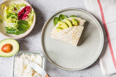 Cooking process for sandwich and ingredients. Process of prepare quesadilla with avocado, salmon, curd cheese and spinach. Trendy wrap hack. step by step. Step 4の写真素材