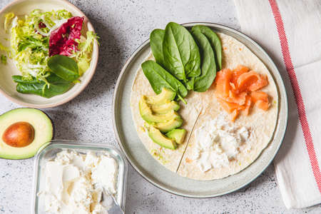 Cooking process for sandwich and ingredients. Process of prepare quesadilla with avocado, salmon, curd cheese and spinach. Trendy wrap hack. step by step. Step 1の写真素材