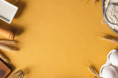 Frame of food ingredients for baking on a yellow background. Cooking flat lay with copy space. top view. Baking concept. mockup.の写真素材