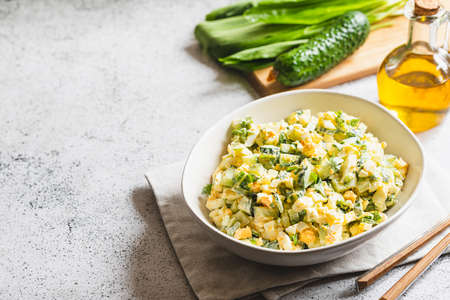 Healthy salad of green wild leek, poached egg and cucumber, close up. Wild garlic salad with boiled eggs.の写真素材