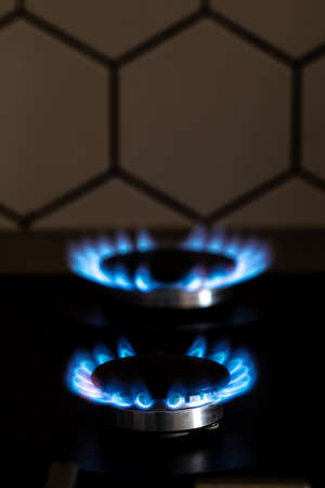 Closeup shot of blue fire from domestic kitchen stove top. Burning gas, gas stove burner. Gas cooker with burning flames of propane gas. Industrial resources and economy concept.の写真素材