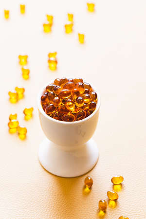 Vitamin D3 capsules. Medicine vitamins and dietary supplements. selective focus. Close up of oil filled capsules suitable for: fish oil, omega 3, omega 6, omega 9, vitamin A, vitamin D, vitamin D3, vitamin Eの写真素材
