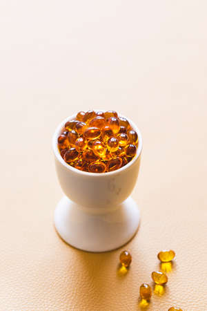 Vitamin D3 capsules. Medicine vitamins and dietary supplements. selective focus. Close up of oil filled capsules suitable for: fish oil, omega 3, omega 6, omega 9, vitamin A, vitamin D, vitamin D3, vitamin Eの写真素材