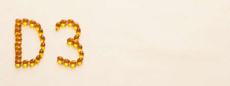 Bright oil yellow pills forming shape D3. Vitamin D3 capsules. Medicine vitamins and dietary supplements. selective focus.の写真素材