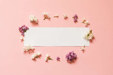 lilac flowers with white card. Creative congratulations layout from lilac on white papper. spring flower concept. Flat lay, top view, copy space.の写真素材