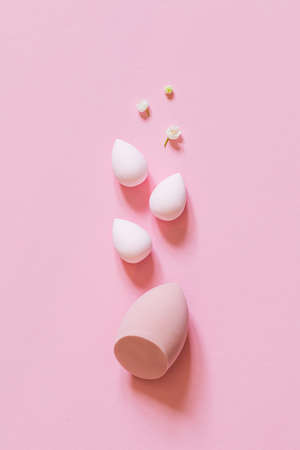 makeup sponge on a minimal pink background. A set of sponges of different egg shapes. Tool for...