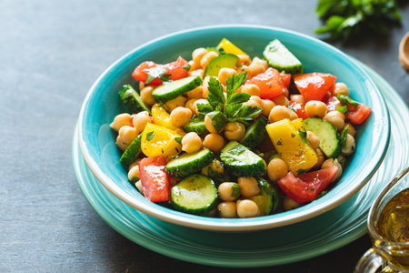 Chickpea salad with tomatoes, cucumber, parsley, onions in a plate, selective focus. Healthy vegetarian food, oriental and Mediterranean cuisine. Chickpeas saladの写真素材