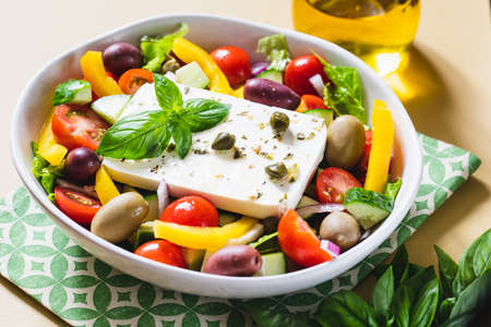 Classic Greek salad of fresh cucumber, tomato, sweet pepper, lettuce, red onion, feta cheese and olives with olive oil.の写真素材