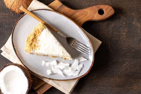 piece of coconut cheesecake on a plate with fresh coconut.の写真素材