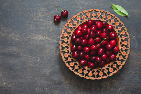 Composition of sweet cherries on a plate with water drops. Summer and harvest concept. Cherry macro. Vegan, vegetarian, raw foodの写真素材