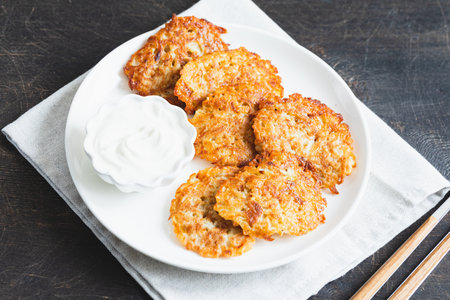 Potato pancakes or latkes or draniki with sour cream. Ukrainian food. A grated potato dish of Deruny or Dranikiの写真素材