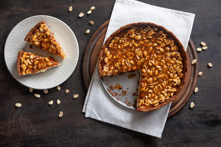 Homemade caramel-peanut cheesecake on a dark background. Morning delicious bakery cake.の写真素材