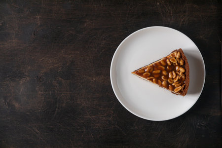 Homemade caramel-peanut cheesecake on a dark background. Morning delicious bakery cake.の写真素材