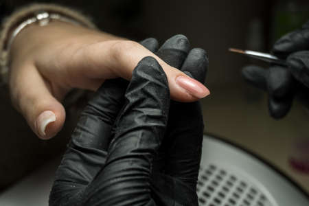 Beauty salon manicure session. Woman in beauty spa salon doing manicure. Close up beautiful manの写真素材