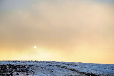 amazing winter sunrise through fog in the mountainsの写真素材