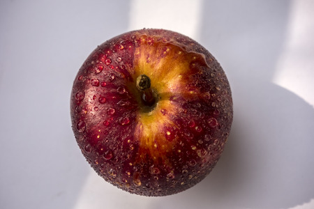 Bright red apple with water drops isolated on white background.