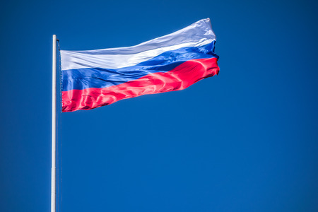 Russian Flag on Flagpole Waving in front of Blue Sky. Flag of Russia.の写真素材