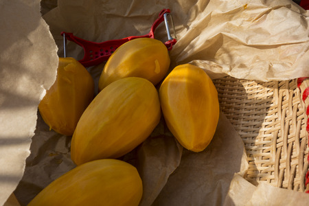 Peeled mangoes and a knife for cleaning them lie on the paper in the basket before you make the juice from them.の写真素材