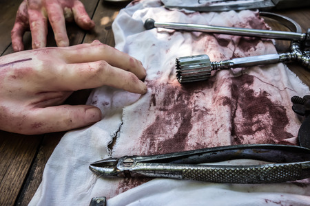 Surgical instruments for amputation surgery lie on bloody white rags on the table. Military field hospitalの写真素材