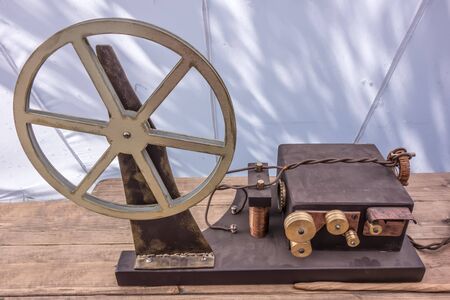The ancient technological device for military and civilian purpose on wooden table on white...
