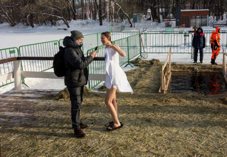 Moscow, Russia, 01/19/2022: Russian people are dipped into an ice hole on the day of the Epiphany. Epiphany bathing in the ice hole in winter. Traditional ice swimming in Orthodox church Holy Epiphany Day.のeditorial素材