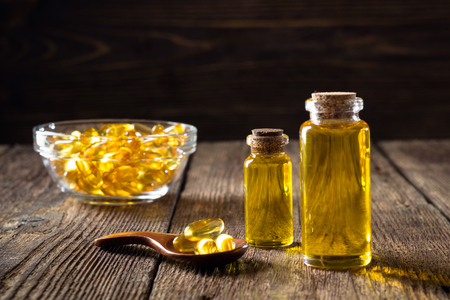 Fish oil capsules on wooden background, vitamin D supplementの写真素材