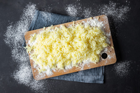 Grated boiled potatoes with flour for the preparation of an Italian dish - potato gnocchi. Black...