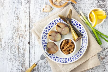 Beer snack - smoked fish mackerel and crispy croutons on white wooden table.の写真素材