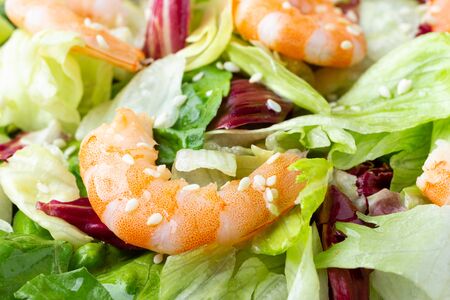 Close-up view of a vegetable shrimp salad with lettuce and sesame seeds.の写真素材