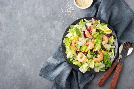 Shrimp salad with flax seeds in a black plate. Gray concrete background. Top view with copy space.の写真素材