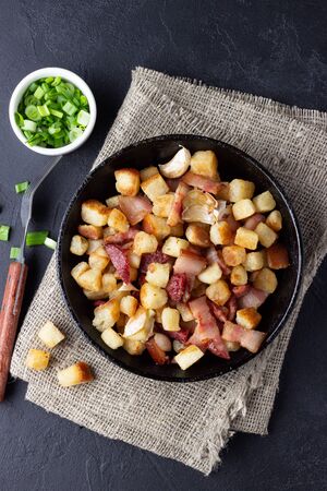 Traditional dish of Spanish cuisine - migos from bread in a black pan.の写真素材