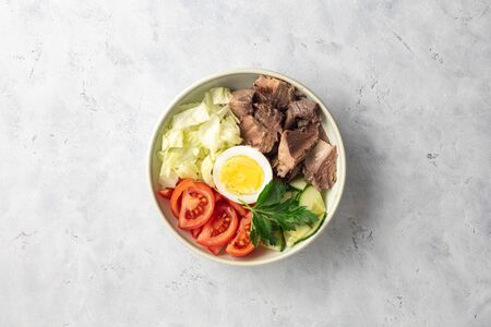Salad with canned tuna, egg and vegetables - tomatoes, cucumber and lettuce. Top view, flat lay.の写真素材