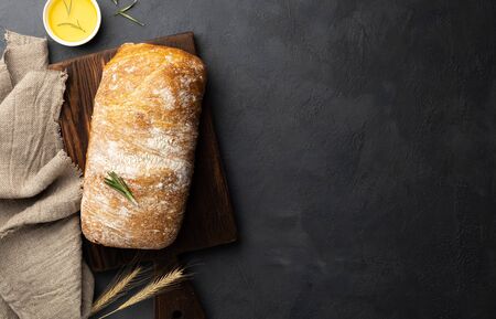Sliced Italian ciabatta bread on black background. Top view, flat lay. Copy space for text.