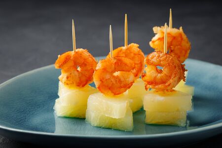Canapes with shrimp and pineapple. Party food. Dark background.の写真素材