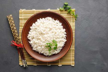Boiled rice, chopsticks and bamboo napkin on a gray concrete background. Asian food. Top view.の写真素材