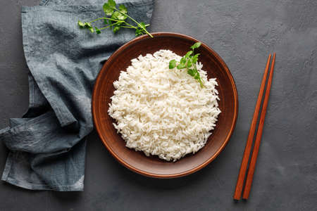 Boiled rice, chopsticks and napkin on a gray concrete background. Asian food. Top view.の写真素材