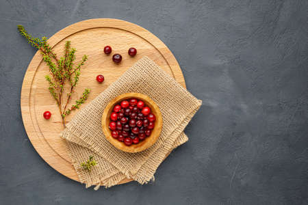 Northern forest berry cranberries on a round wooden cutting board. Menu conceptの写真素材