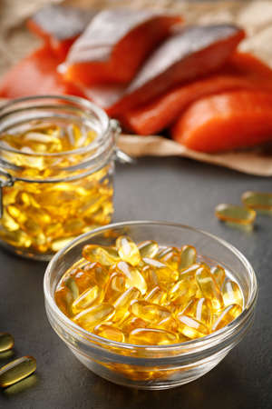 Vitamin D supplement concept - omega 3 capsules and salmon red fishの写真素材