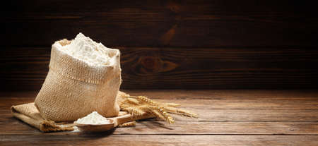 Flour in burlap bag on a wooden background. Copy space for text.の写真素材