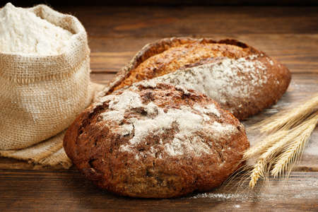 Freshly baked traditional bread on a wooden table.の写真素材