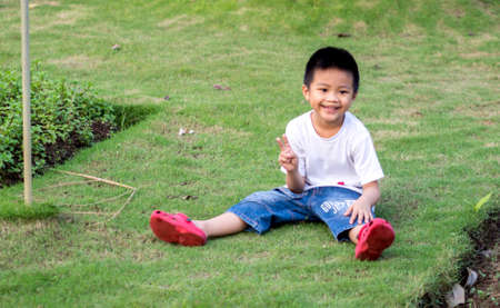 Chinese Child (boy) Sit on The Grassの写真素材