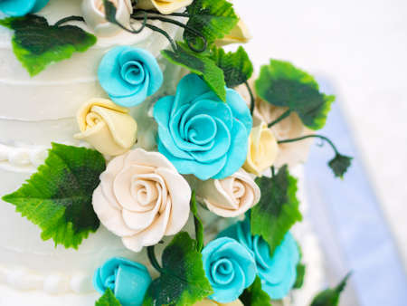 Beautiful wedding cake with blue and yellow rosesの写真素材