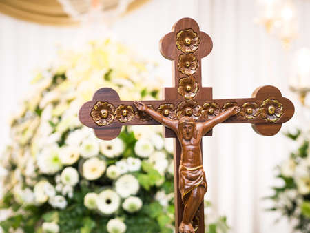 Wooden Jesus Christ on Cross with Flower Backgroundの写真素材