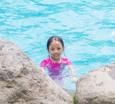 Portrait of smiling Asian Girl (Kid) at Pool Sideの写真素材
