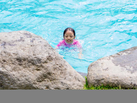Asian Kid (Girl) in Swimming Pool with Finger Pointingの写真素材